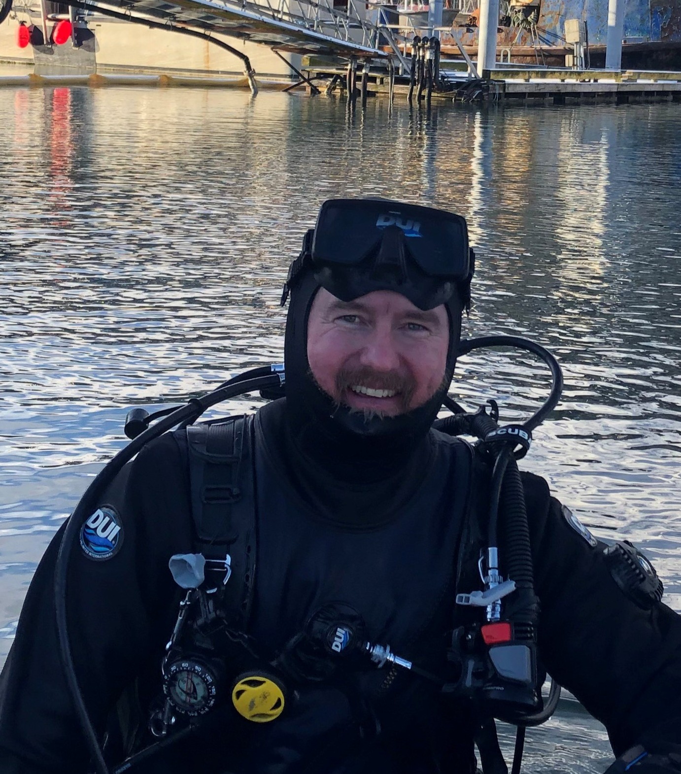 Ben Wilkins in scuba diving gear beside the water